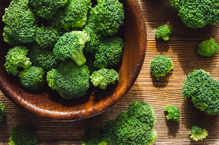 Fresh Washed Broccoli Florets in Teak Bowl on Cedar Wood Table