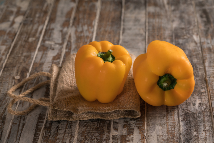 Yellow bell pepper on the wood background